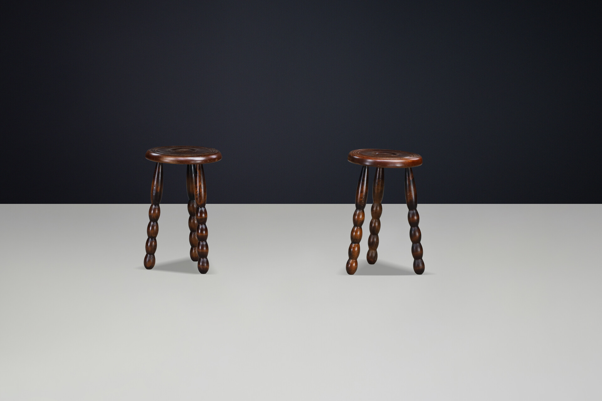 Brutalist Sculptural pair of French Brutalist stools crafted in solid walnut, designed in the manner of Charles Dudouyt, France, circa 1940s. Mid-20th century