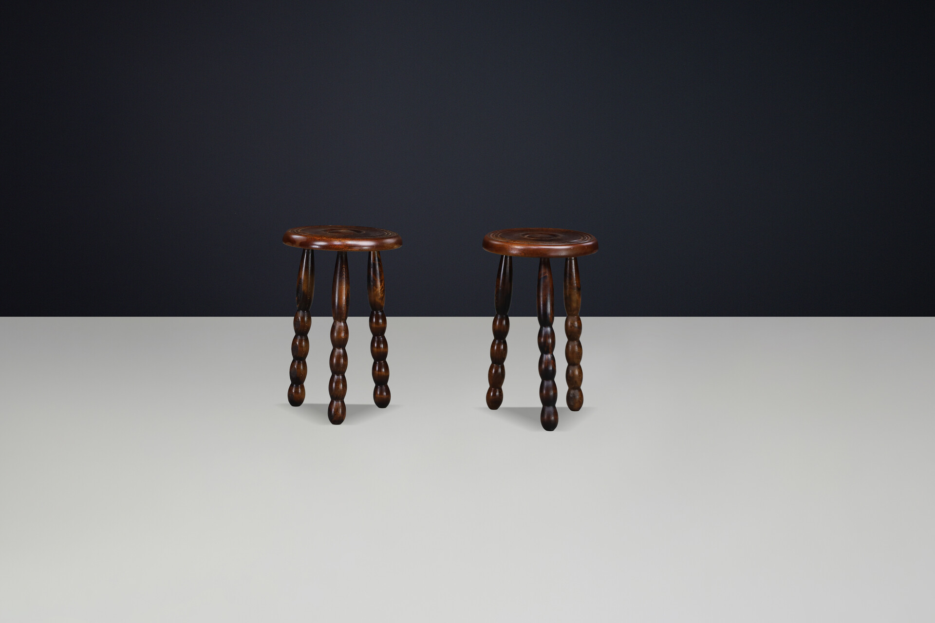 Brutalist Sculptural pair of French Brutalist stools crafted in solid walnut, designed in the manner of Charles Dudouyt, France, circa 1940s. Mid-20th century